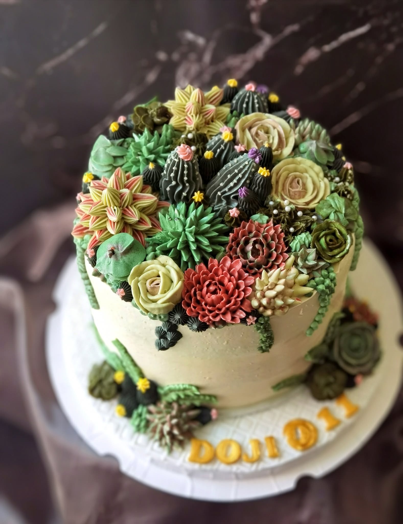 A buttercream succulent and cactus garden cake by 21Treats
